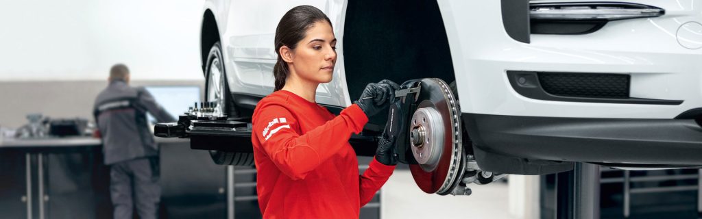 Porsche technician working on brakes